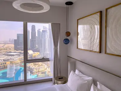 a bedroom with a bed and a large window at GRANDE SIGNATURE RESIDENCES direct Burj Khalifa view and Private Fountain Show at high floor with DXB AIRPORT VIP Shuttle option in Dubai