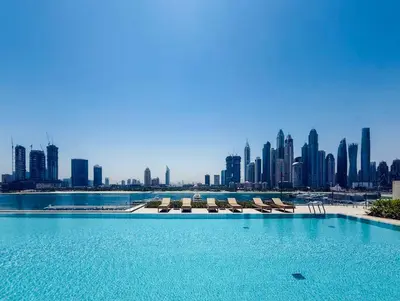 a swimming pool with chairs and a city skyline at Luxury Sea View 1BR l Palace Beach Residence in Dubai