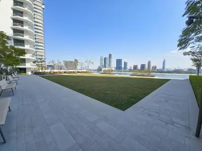 a walkway in a park with a lawn and buildings at Luxury Sea View 1BR l Palace Beach Residence in Dubai