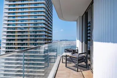 a balcony with chairs and a table on a building at Luxury Sea View 1BR l Palace Beach Residence in Dubai