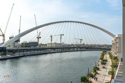 a bridge over a river next to a body of water at Canal-Side Living Elegant 2BR at Canal Front in Dubai