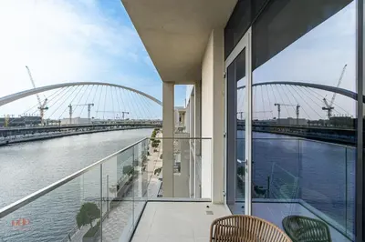 a balcony with a view of a river and a bridge at Canal-Side Living Elegant 2BR at Canal Front in Dubai