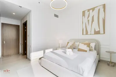 a white bedroom with a large white bed in it at Canal-Side Living Elegant 2BR at Canal Front in Dubai