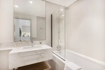 a white bathroom with a sink and a mirror at Beachfront stay at Beach Mansion with Private Beach in Dubai