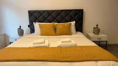 a bedroom with a large bed with yellow pillows at 1BDR Centrally Located Near Metro in Dubai