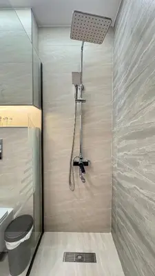 a bathroom with a shower with a toilet and a light at 1BDR Centrally Located Fully Equipped Kitchen in Dubai