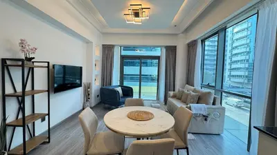 a living room with a table and a couch at 1BDR Centrally Located Fully Equipped Kitchen in Dubai