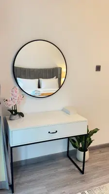 a mirror on top of a white dresser in a room at 1BDR Centrally Located Fully Equipped Kitchen in Dubai