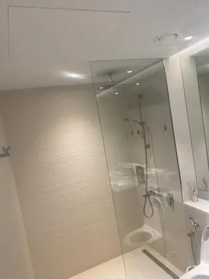 a shower with a glass door in a bathroom at La Cote, free Beach access in Dubai