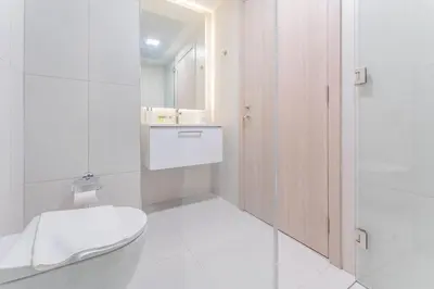 a white bathroom with a toilet and a shower at HAVN - 1 bed in Luma Parks, JVC in Dubai
