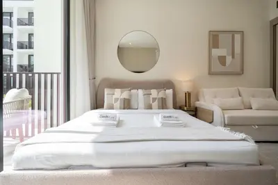 a bedroom with a large white bed and a mirror at Boutique Studio at Binghatti Aurora by Czechin in Dubai