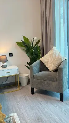 a living room with a chair and a table at Studio Centrally Located Near to Metro in Dubai