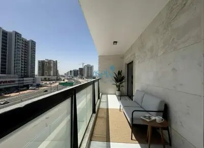 a balcony with a couch and a view of a city at Modern 1BHK Equiti Arcade- Al Furjan -Near Metro in Dubai