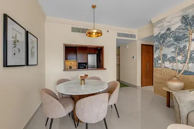 a dining room with a table and chairs at Waves - Luxury 2BR Apt With Burj Khalifa & Fountain View in Dubai