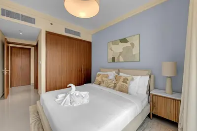 a bedroom with a white bed with a white swan on it at Waves - Luxury 2BR Apt With Burj Khalifa & Fountain View in Dubai
