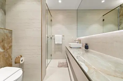 a bathroom with a toilet and a sink and a shower at VayK - Bright Modern Apartment in JVC - 1BR Gem in Dubai