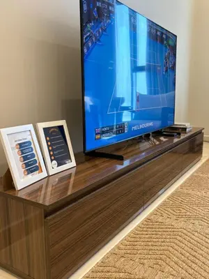 a flat screen tv sitting on top of a wooden entertainment center at Stylish 2BR in Business Bay with all essentials in Dubai