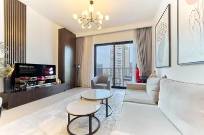 a living room with a couch and a tv at Bright 1BR in Executive Residences 2, Dubai Hills in Dubai