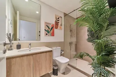 a bathroom with a toilet and a sink and a plant at Bright 1BR in Executive Residences 2, Dubai Hills in Dubai