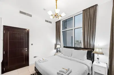 a bedroom with a bed and a large window at Modern 2BDR Stay-Near Metro-Al Furjan in Dubai