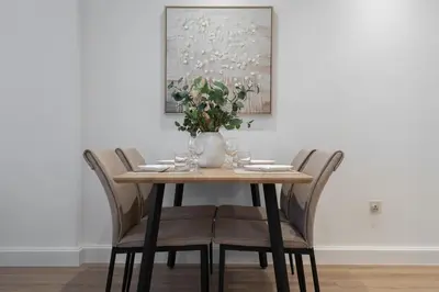 a table with chairs and a vase with flowers on it at Modern 1BHK Jewels Tower, Dubai Marina by Czechin in Dubai