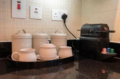 a counter with four coffee cups and a toaster at Modern 1BHK Jewels Tower, Dubai Marina by Czechin in Dubai