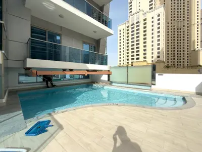 a shadow of a person standing next to a swimming pool at Modern 1BHK Jewels Tower, Dubai Marina by Czechin in Dubai