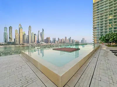 a large pool of water with a city in the background at VayK - Elegant 2BR at Emaar Beachfront with Beach Access in Dubai