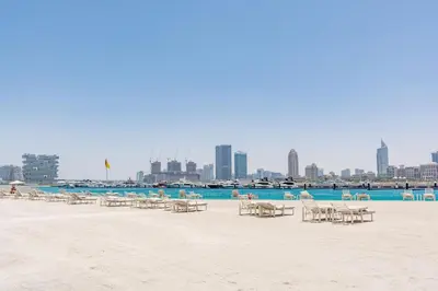 a group of chairs and tables on a beach at VayK - Elegant 2BR at Emaar Beachfront with Beach Access in Dubai
