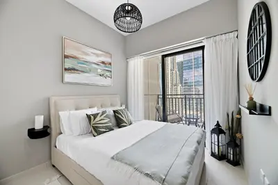 a white bedroom with a large bed and a balcony at VayK - Newly Launched 1BR in Business Bay in Dubai