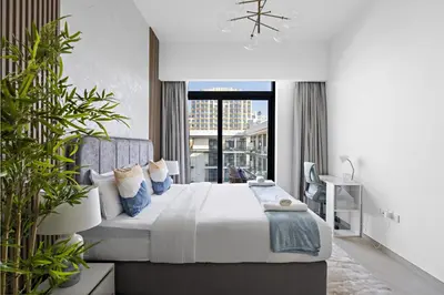 a bedroom with a large bed with blue pillows at VayK - Contemporary 1BR in a New JVC Community in Dubai