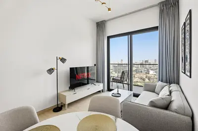 a living room with a couch and a tv at VayK - Comfortable 1BR in JVC in Dubai