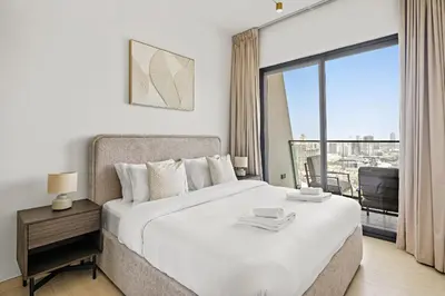 a bedroom with a bed and a large window at VayK - Comfortable 1BR in JVC in Dubai