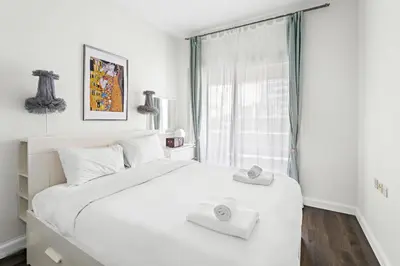 a bedroom with a large white bed with towels on it at VayK - Modern 1BR Near Metro in Dubai Marina in Dubai
