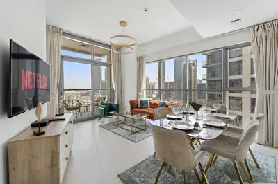 a living room with a dining table and a large window at VayK - Generous 2BR Offering Burj Khalifa Views in Dubai
