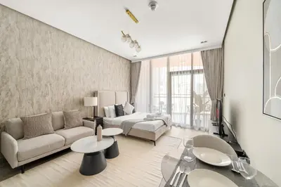 a living room with a couch and a bed at VayK - Chic Studio in Silicon Oasis with Pool View in Dubai