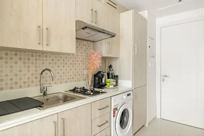 a kitchen with a sink and a washing machine at VayK - Contemporary Studio with Beach Access on Palm Jumeirah in Dubai