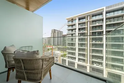 a balcony with two chairs and a large window at VayK - Refined Studio in Dubai Hills with Pool View in Dubai