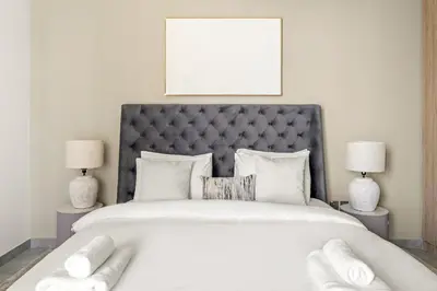 a bedroom with a large white bed with two lamps at VayK - Sunlit Studio with Canal Views in Business Bay in Dubai