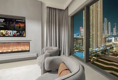 a living room with two chairs and a fireplace at Signature Luxury Apartments Downtown Dubai in Dubai
