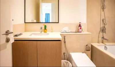 a bathroom with a sink and a mirror and a tub at Prime Downtown Luxury Stays by Burj Khalifa in Dubai