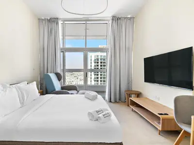 a hotel room with a bed and a large window at Trendy Luxe Studio In Al Furjan close to Metro-17 in Dubai