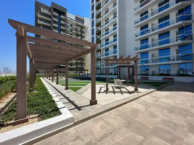 a group of wooden shelters in front of a building at Trendy Luxe Studio In Al Furjan close to Metro-17 in Dubai