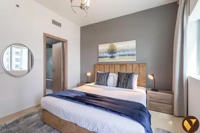 a bedroom with a large bed and a mirror at Vogue Marina Diamond Near JBR Beach and Marina Mall, Two Bedroom Apartment with Balcony and City View, Access to all Amenities, Walkable to Sobha Realty Metro Station and Bus Stop in Dubai