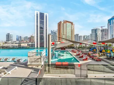 a pool on the roof of a building with a city at Spacious Studio with Balcony I Near Dubai Mall & Downtown in Dubai