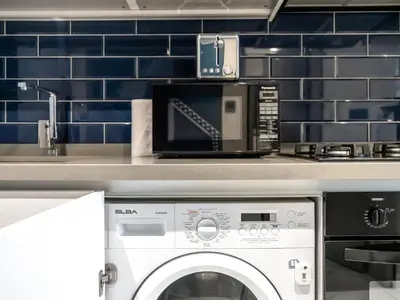 a kitchen with a microwave and a washing machine at Spacious Studio with Balcony I Near Dubai Mall & Downtown in Dubai