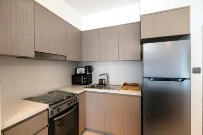 a kitchen with a stainless steel refrigerator and a sink at Chic Downtown Act Tower Walk to Burj Khalifa&Mall in Dubai