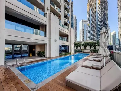 a pool in a building with chairs and an umbrella at Chic Downtown Act Tower Walk to Burj Khalifa&Mall in Dubai