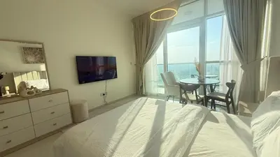 a bedroom with a bed and a table with chairs at Modern Luxury Studio Damac Hills With Golf View in Dubai
