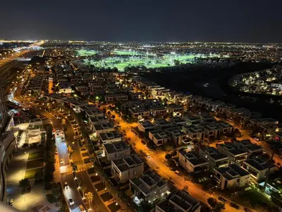 an aerial view of a city at night at Modern Luxury Studio Damac Hills With Golf View in Dubai